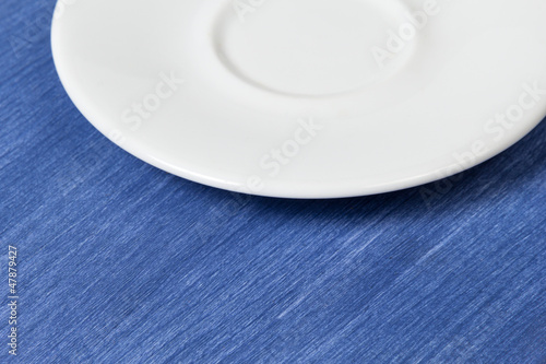 empty saucer on blue wooden surface