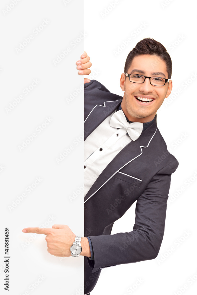 Stylish handsome guy pointing with finger on a panel Stylish handsome guy pointing with finger on a panel