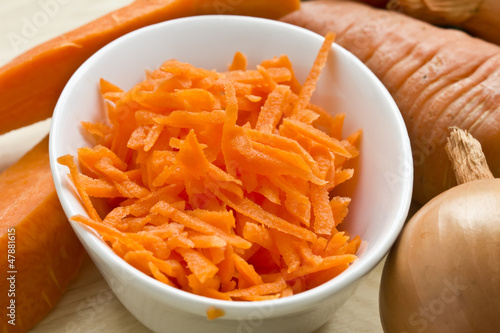 Grated carrots in bowl on table