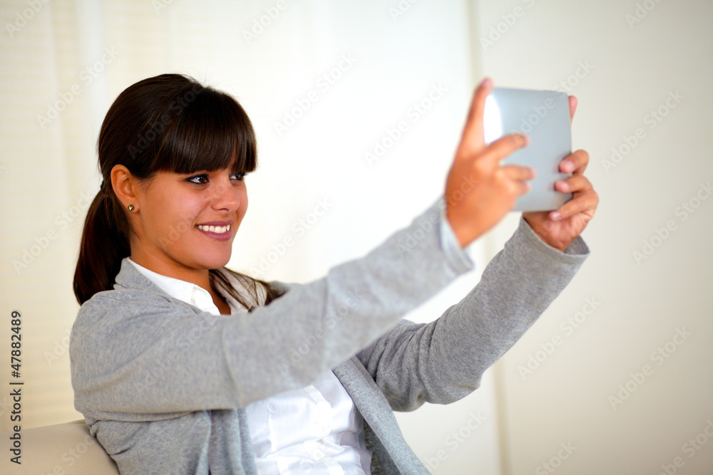 Smiling young woman taking picture with tablet pc Smiling young woman taking picture with tablet pc