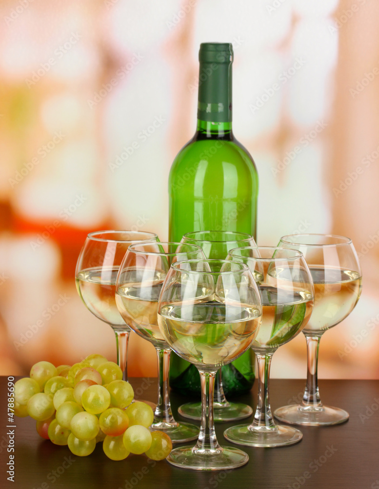 White wine in glass and bottle on room background