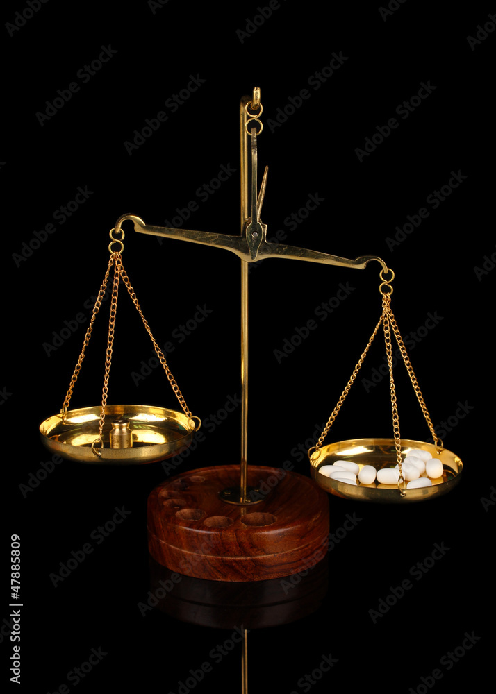 Classic scales with color pills isolated on black Classic scales with color pills isolated on black