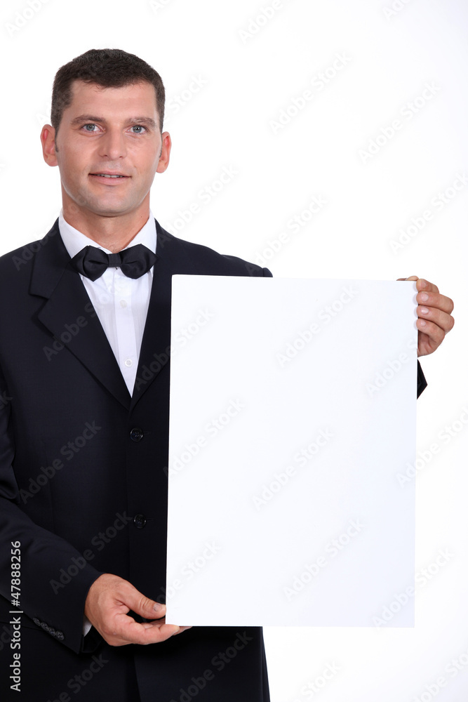 Man wearing bow-tie holding white board Man wearing bow-tie holding white board