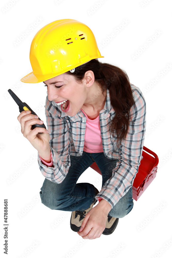 Woman sitting on toolbox with radio in hand Woman sitting on toolbox with radio in hand
