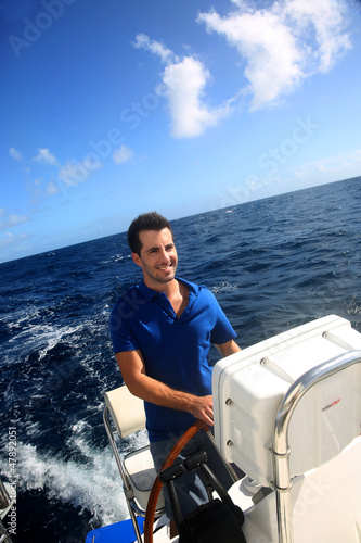 Smiling young sailor navigating in Caribbean sea