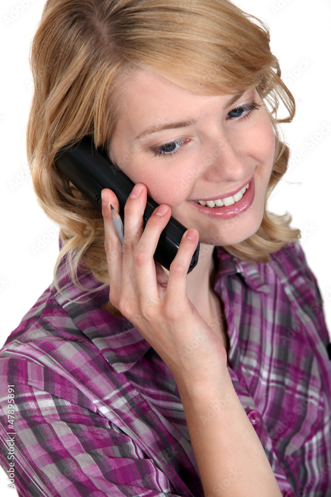 Casual woman on the phone with a pencil in hand Casual woman on the phone with a pencil in hand