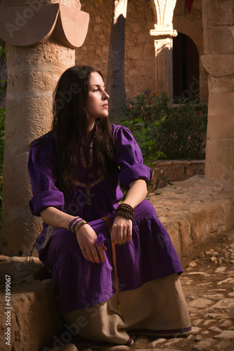 Brunette girl in a medieval suit in a Agia Napa Medieval Monaste photo