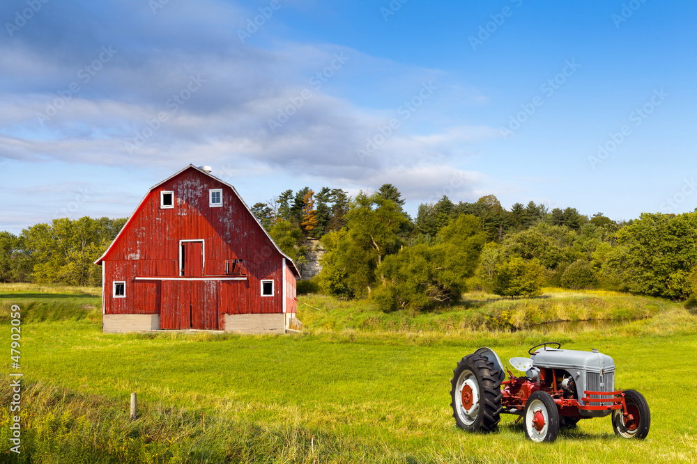 Naklejka premium Traditional American Red Barn With Vintage Tractor