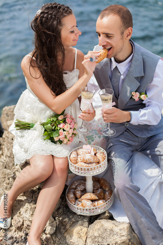 bride and groom celebrating on cliffs by the sea with champagne