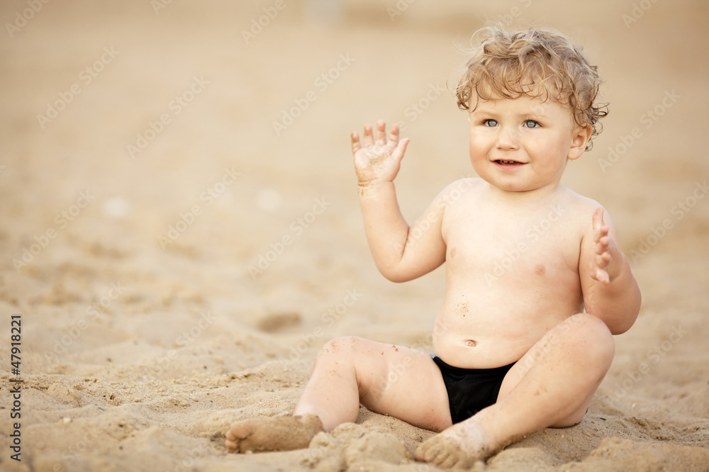 little funny boy plays on beach