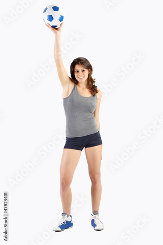 Portrait of a girl who lifts a ball with one arm