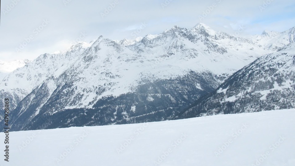 Group of tourists go up on ski line against mountain tops Group of tourists go up on ski line against mountain tops