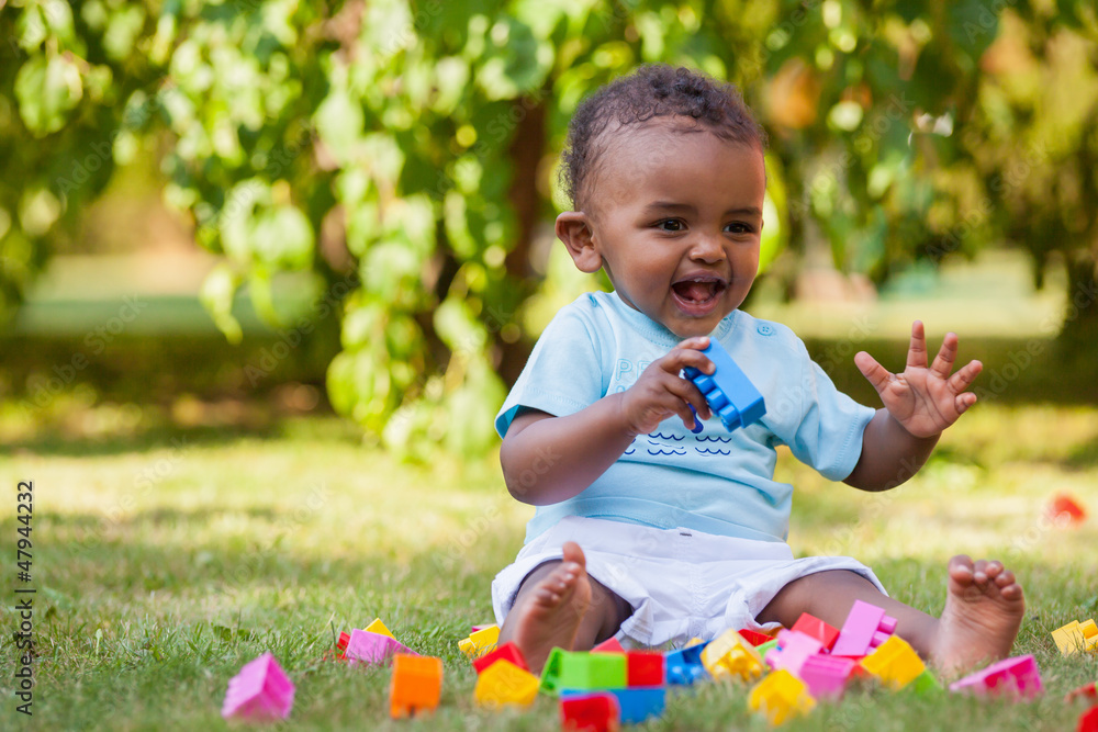 Little african american baby boy playing in the grass Little african american baby boy playing in the grass