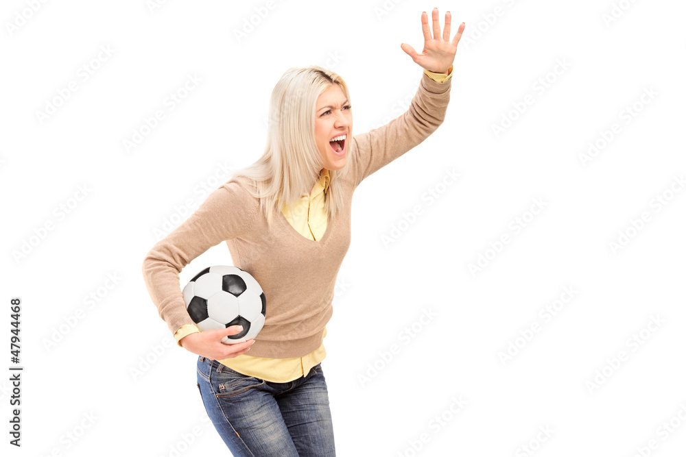 A female sport fan holding a football and shouting A female sport fan holding a football and shouting