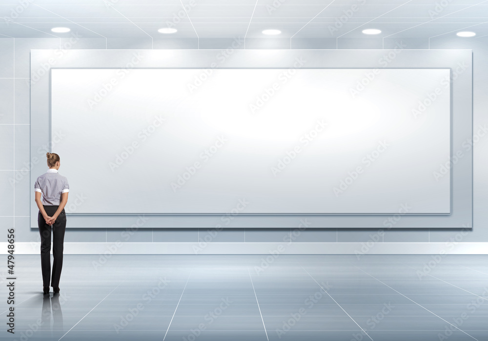 Business person standing near a blank billboard Business person standing near a blank billboard
