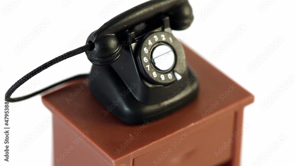 Black toy phone on small table spins isolated Black toy phone on small table spins isolated