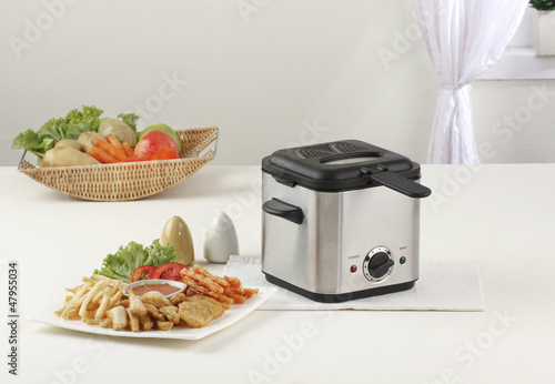 Fototapet Let's do your french fry by using deep fryer machine