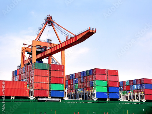 Photography Container stacks on board under crane bridge