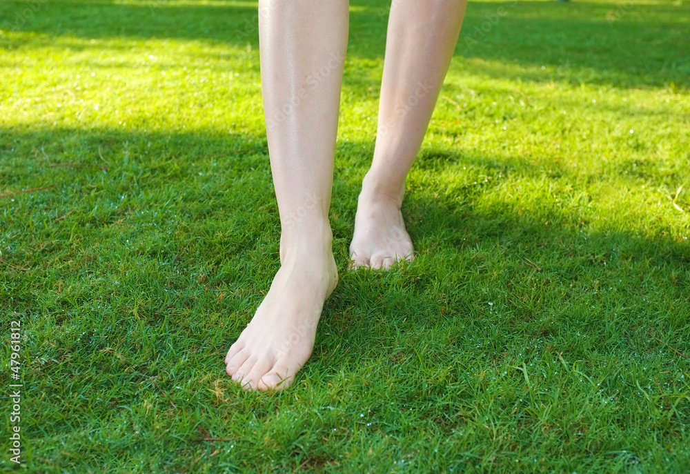 Legs walking on green lawn.