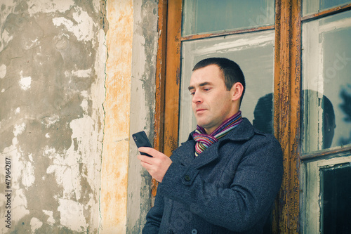 The man in warm jacket with mobile phone photo