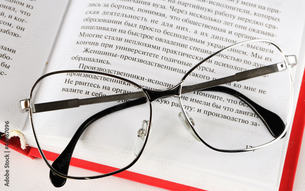Eyeglasses lies on a open book