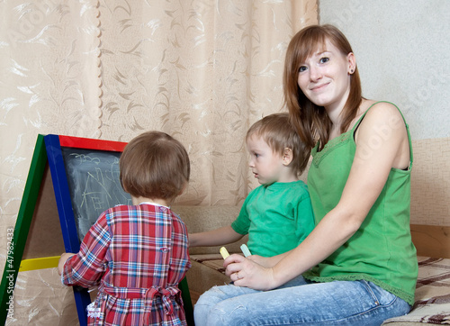 Woman and children draws on  blackboard photo