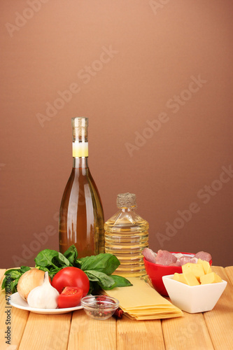 Lasagna ingredients on brown background