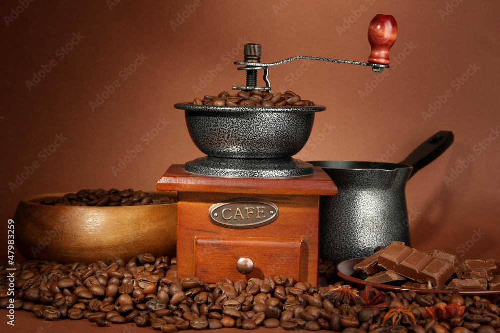 Coffee grinder, turk and coffee beans on brown background Coffee grinder, turk and coffee beans on brown background