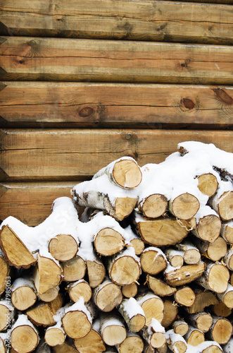 Birch fire wood at a wall of the house in winter