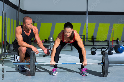 gym personal trainer man with weight lifting bar woman