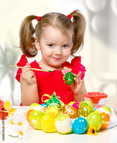 girl paints eggs