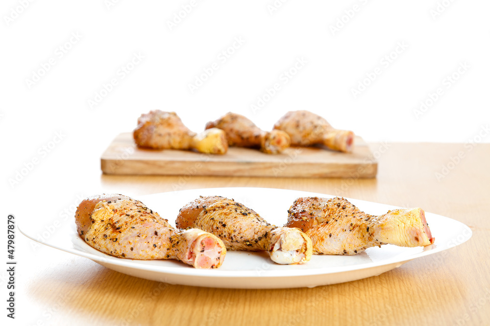 Marinated chicken legs on plates Marinated chicken legs on plates