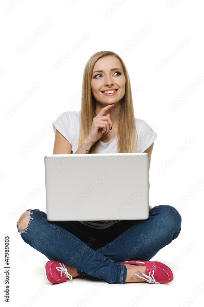 Pensive woman sitting with laptop on the floor Pensive woman sitting with laptop on the floor