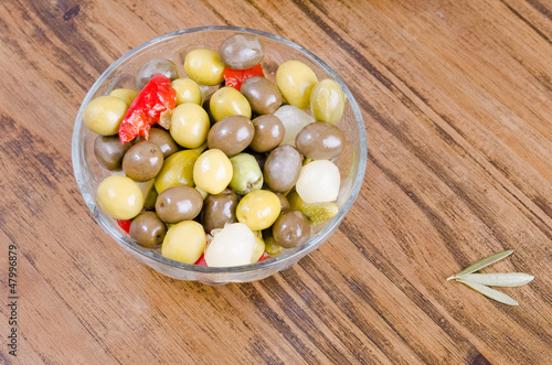 Olives and pickles on wood table