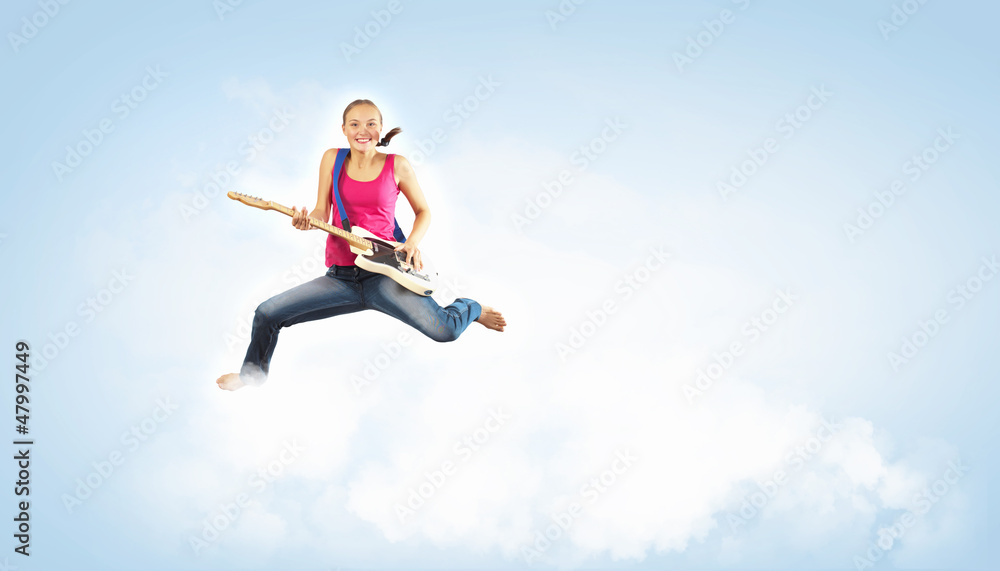 young woman playing on electro guitar and jumping young woman playing on electro guitar and jumping