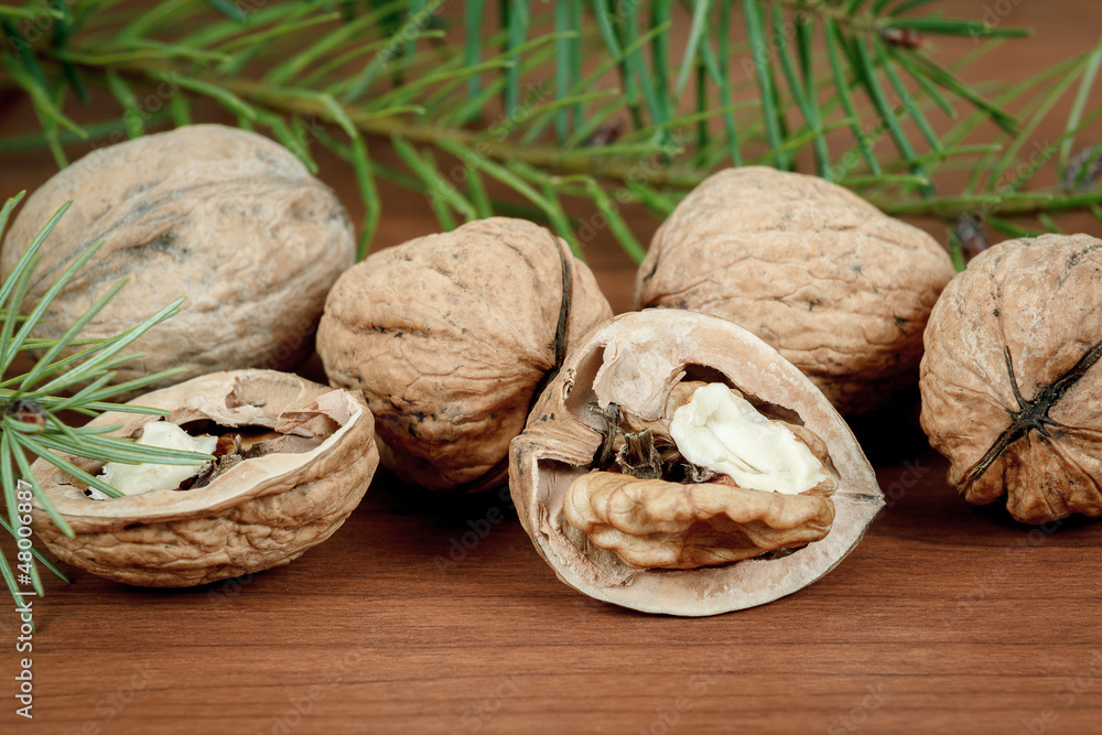 walnuts and a cracked walnut on wooden background walnuts and a cracked walnut on wooden background