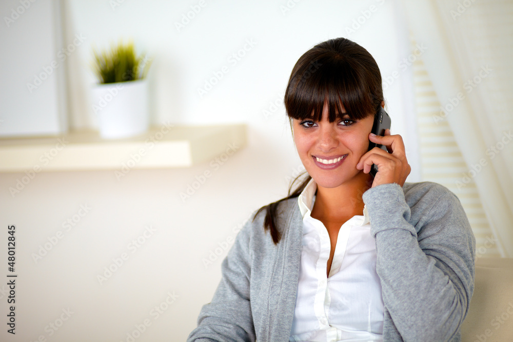 Positive smiling female conversing on cellphone Positive smiling female conversing on cellphone