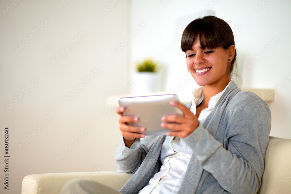 Smiling young woman using her tablet pc Smiling young woman using her tablet pc