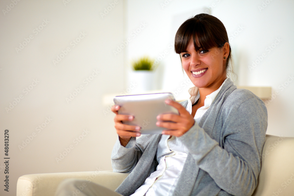 Smiling young female using her tablet pc Smiling young female using her tablet pc