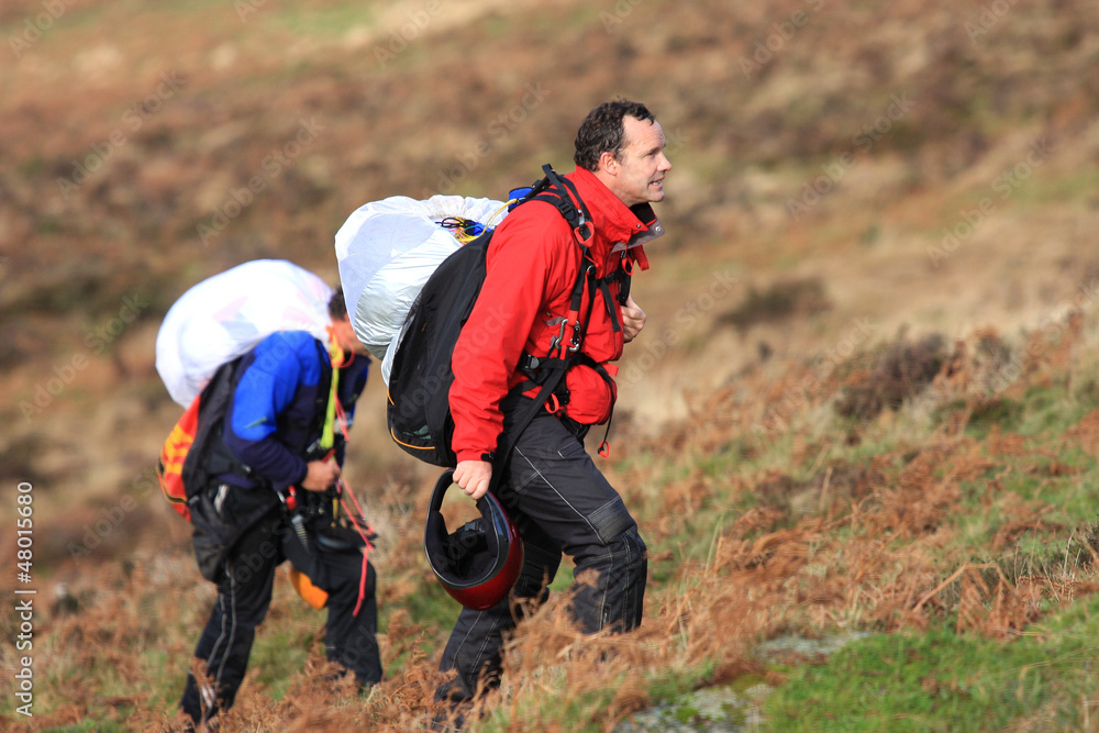 paragliders walking up hill