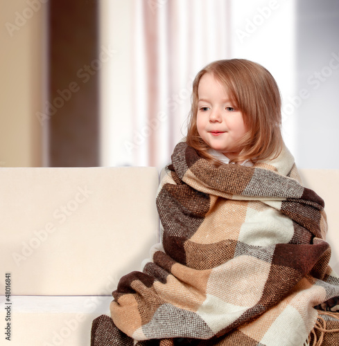 girl dressed in a blanket sitting on the couch