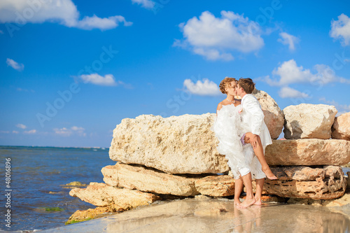 Couple hugging on beach posing background of blue sea and sky