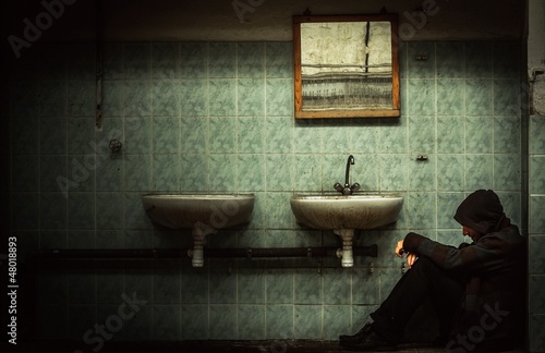 An abandoned industrial interior with a depressed man