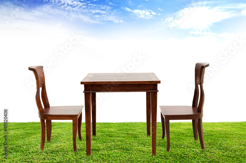 wooden chairs and table on green grass  beautiful blue sky