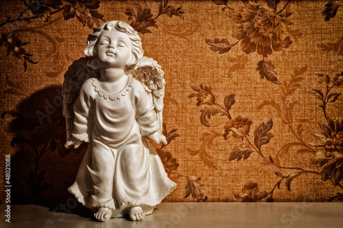 Vintage cupid sculpture with floral background