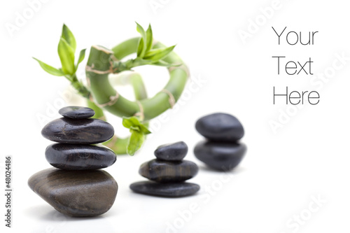 Pile of shiny zen pebble stones with bamboo plant