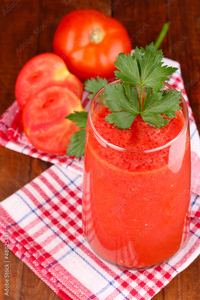Glass of tomato juice on wooden table Glass of tomato juice on wooden table
