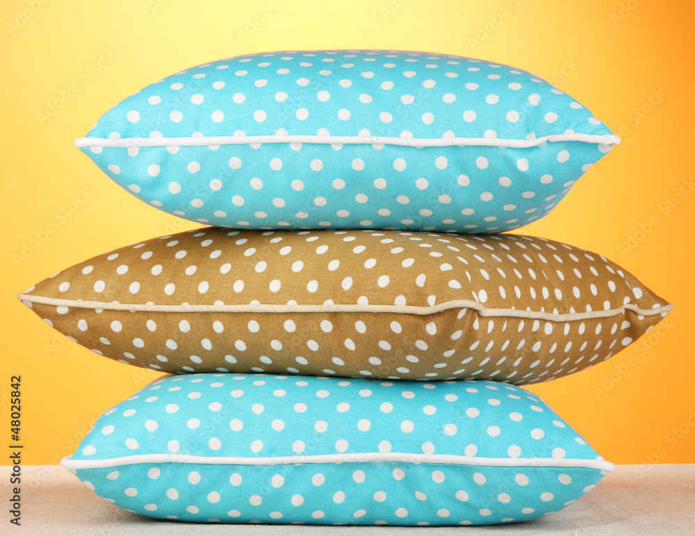 Fototapeta premium Blue bright pillows on orange background