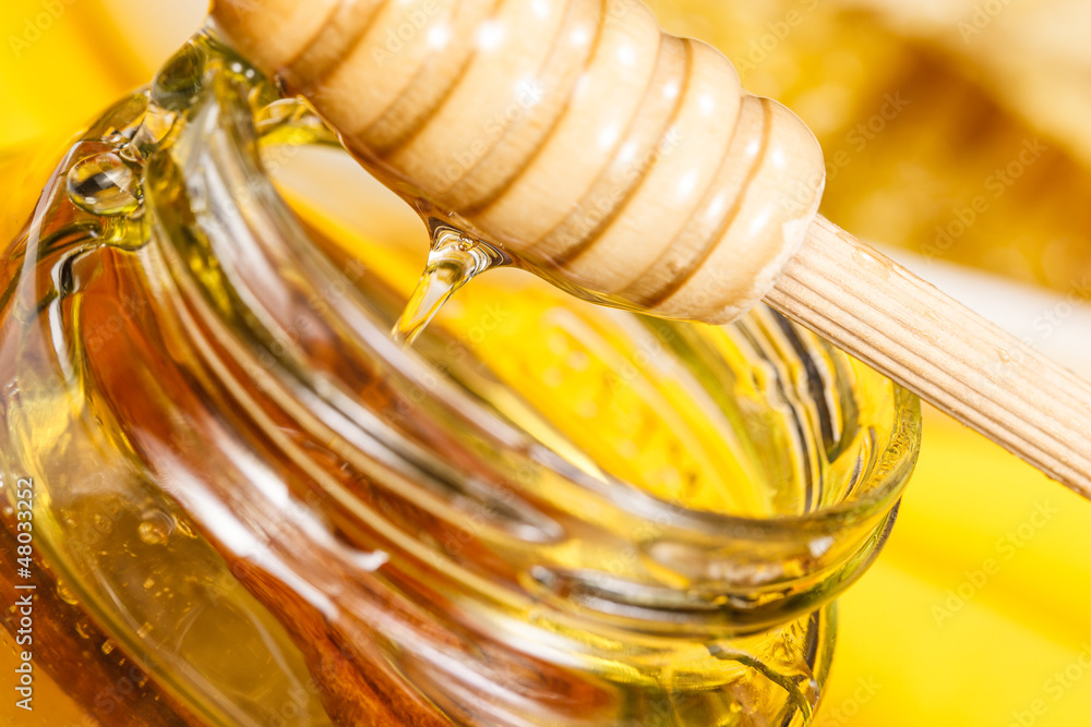 Jar of honey with a wooden drizzler Jar of honey with a wooden drizzler