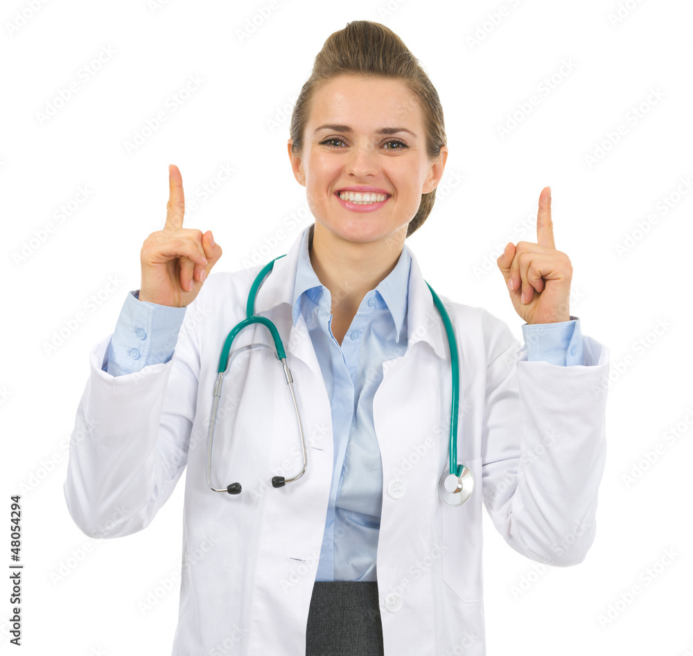 Smiling medical doctor woman pointing up Smiling medical doctor woman pointing up